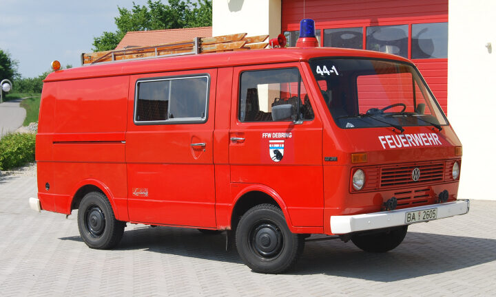 Roter Feuerwehrbus vor Feuerwehrhaus
