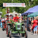 Oldtimer-Traktor bei Dorffest mit Willkommen-Banner