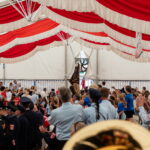 Festzelt mit applaudierender Menschenmenge in Uniformen