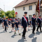 Festumzug mit Feuerwehr und Kindern im Dorf