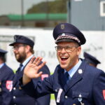 Feuerwehrmann in Uniform winkt bei Veranstaltung